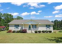 Charming single-story brick home featuring a welcoming front porch and well-manicured landscaping at 4684 Bluff Rd., Mullins, SC 29574