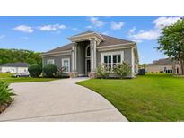 Inviting one-story home featuring a well-manicured lawn and a stately, columned entrance at 482 Pomo Dr., Myrtle Beach, SC 29579