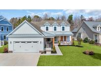 Charming two-story home with a welcoming front porch, lush lawn, and attached two-car garage at 5049 Middleton View Dr., Myrtle Beach, SC 29579