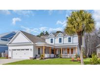 Charming two-story home with white siding, wood accents, a lush lawn, and a welcoming front porch at 5049 Middleton View Dr., Myrtle Beach, SC 29579