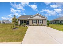 Charming single-story home featuring a well-maintained lawn and a long driveway at 509 Wildfire Ct., Longs, SC 29568