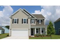 Charming two-story home featuring a two-car garage, neutral siding, and classic black shutters against a bright blue sky at 6027 Forest Dell Ct, Myrtle Beach, SC 29579