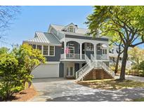 Inviting two-story home featuring a metal roof, a quaint porch, lush yard, and convenient garage at 675 Wedgewood Dr., Murrells Inlet, SC 29576