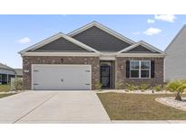 Charming single-story home featuring a brick facade, attached garage and well-maintained landscaping at 7005 Grant St., Little River, SC 29566