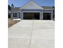 Charming, light blue one-story home with a three-car garage and a new concrete driveway at 187 Glengrove Lane, Murrells Inlet, SC 29576