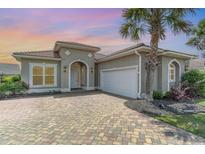 Charming home with a tile roof, paver driveway, and lush landscaping including mature palm tree at 197 Northside Dr., Little River, SC 29566