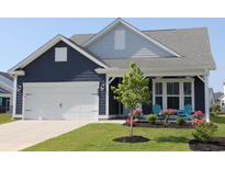 Charming home featuring a two-car garage and a cozy front porch with seating and manicured landscaping at 2005 Tiller Ct., Myrtle Beach, SC 29579