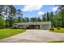 Charming one-story brick home with a well-manicured front yard and an attached carport at 2192 Highway 308, Galivants Ferry, SC 29544
