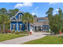 Charming blue two-story home with a well-manicured front yard, palm trees, and welcoming curb appeal at 2615 Painted Trillium Ct., Myrtle Beach, SC 29579