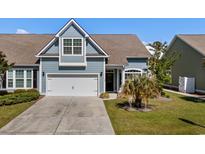 Charming blue home featuring an attached garage and well-maintained front yard at 320 Saint Catherine Bay Ct., Surfside Beach, SC 29575