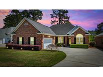 Beautiful brick home with manicured lawn and professional landscaping at 3224 Hermitage Dr., Little River, SC 29566