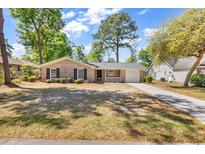 Charming brick home with black shutters, a well-manicured lawn, and a cozy front porch at 333 14Th Ave. S, Surfside Beach, SC 29575