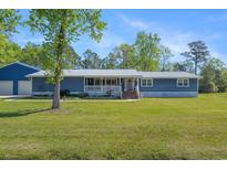 Charming single-story home with a front porch and well-maintained lawn, and metal roof at 3759 Cypress Dr., Little River, SC 29566
