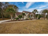 Charming home with palm trees, manicured lawn, and a beautiful facade at 4593 Lake Circle, Little River, SC 29566