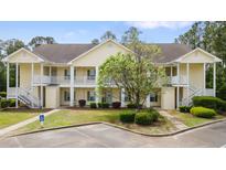 Inviting two-story condo with manicured lawn, staircase entries, and designated handicap parking at 5876 Longwood Dr. # 201, Murrells Inlet, SC 29576
