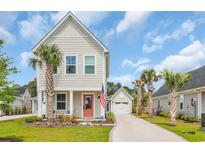 Charming two-story home featuring a delightful coral door, inviting front porch, and well-maintained landscaping at 9012 Mabel Ct., Longs, SC 29568