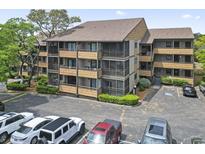 Condo exterior showing screened in balconies with parking lot in the foreground and landscaping in the mid ground at 9501 Shore Dr. # B-316, Myrtle Beach, SC 29572