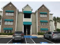 Beautiful exterior view of a condo building featuring stone accents and teal awnings with accessible parking at 9739 Leyland Dr. # 12, Myrtle Beach, SC 29572