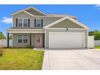 Charming two-story home featuring a two-car garage and a vibrant pink front door at 1008 Corn Husk Loop, Conway, SC 29527