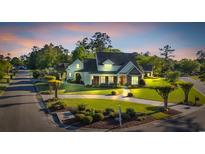 Beautiful traditional home with manicured lawn, lovely landscaping, and circular driveway at 107 Long Bay Golf Pl., Longs, SC 29568