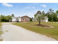 Charming single-Gathering home featuring a brick facade, landscaped yard, and separate garage at 175 Cypress Ln., Little River, SC 29566