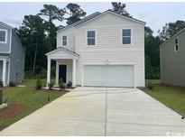Charming two-story home with a classic white exterior, complemented by a well-maintained lawn and a spacious driveway at 378 Ladyfish Loop, Sunset Beach, NC 28468
