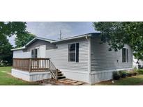 Charming mobile home featuring light gray siding and a small wooden porch with traditional railings at 3802 Stern Dr., Conway, SC 29526