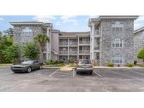 Condo complex featuring classic architecture, brick accents, and convenient parking at 4729 Wild Iris Dr. # 104, Myrtle Beach, SC 29577