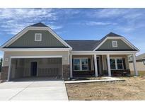 A charming single-Gathering home with a two-car garage is enhanced by stone accents and attractive curb appeal at 962 Oak Hollow St., Longs, SC 29568