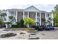 Three-story condo with brick accents, white columns, stairs, and ample parking at 100 Birch N Coppice Dr. # 12, Surfside Beach, SC 29575