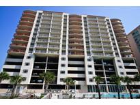 Modern condo tower featuring balconies, parking garage, and a refreshing outdoor swimming pool at 1401 S Ocean Blvd. # 506, North Myrtle Beach, SC 29582