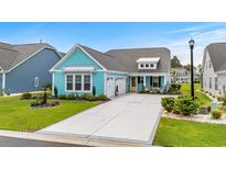 Charming blue home featuring a pristine driveway, manicured lawn, and a convenient two-car garage at 143 Starlit Way, Myrtle Beach, SC 29579