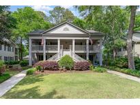 Charming two-story home with double porches, American flags, lush landscaping, and a well-manicured lawn at 146 Stillwood Dr. # 3, Pawleys Island, SC 29585