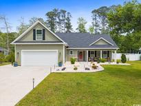 Charming home with a manicured lawn and inviting front porch at 1610 Old Tram Rd., Little River, SC 29566