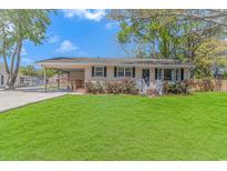 Charming single-story home with a well-manicured lawn, covered parking and vibrant flower bushes lining the front porch at 1931 Jasper St., Georgetown, SC 29440