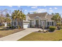 Charming home featuring a well-manicured lawn, palm trees, and a convenient two-car garage at 200 Stonefly Ct., Murrells Inlet, SC 29576