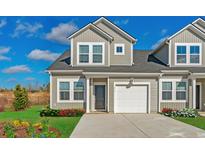 Charming two-story townhome with a one car garage, landscaped front yard, and a concrete driveway at 2107 Victory Way # 496, Myrtle Beach, SC 29579
