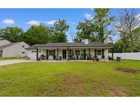 Charming single-story home featuring a well-maintained lawn, inviting front porch and neutral color palette at 4 Catawba Ct., Myrtle Beach, SC 29588
