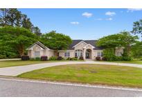 Charming single-story home with lush landscaping and a circular driveway nestled in a quiet neighborhood at 4084 Hagwood Circle, Conway, SC 29526