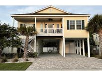 Charming elevated home with a covered porch, white railings, and ground-level covered parking at 412 29Th Ave. N, North Myrtle Beach, SC 29582