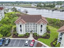 Beautiful three-story condo building near water, with well-maintained landscaping and ample parking at 4616 Greenbriar Dr. # H-4, Little River, SC 29566