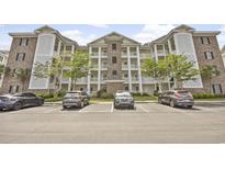 A charming building exterior with brick and white columns that enhance the appeal of the property and its architecture at 4878 Luster Leaf Circle # 402, Myrtle Beach, SC 29577