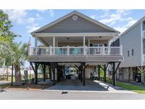 Inviting elevated beach home with covered parking and a charming front porch perfect for enjoying coastal breezes at 6001-1872 S Kings Hwy., Myrtle Beach, SC 29575