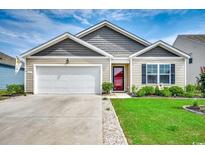 Charming single-story home with a well-maintained lawn, attached garage, and inviting front entrance at 777 Woodland Farms Circle, Aynor, SC 29511