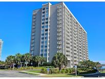 Condo building exterior shot showing meticulous landscaping and beautiful blue skies at 9820 Queensway Blvd. # 704, Myrtle Beach, SC 29572
