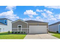 Charming one-story home featuring a modern design, neutral siding, well-kept lawn, and a two-car garage at 1035 Sentinel Ct., Little River, SC 29566