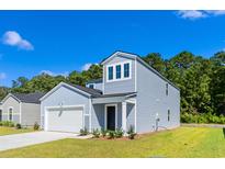 Charming two-story home features light blue siding, a one-car garage, and well-maintained landscaping at 1039 Sentinel Ct., Little River, SC 29566