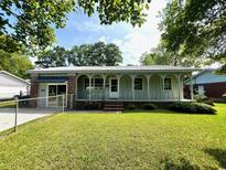 Charming home featuring a covered front porch with arched supports and a well-maintained lawn at 1110 Scott Dr., Myrtle Beach, SC 29577