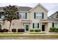 Charming townhome with tan siding, dark green shutters, and landscaped front with manicured bushes and a decorative tree at 130 Scotch Broom Dr. # H-103, Little River, SC 29566