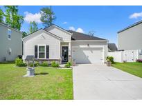 Charming single-story home with a well-manicured lawn and attached garage in a desirable neighborhood at 155 Marsh Deer Place, Surfside Beach, SC 29575